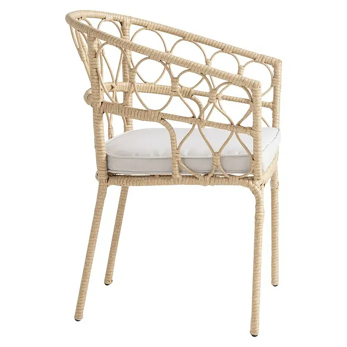 Silla de jardín Marius - Natural, Ratán sintético - Una silla de ratán beige con cojín blanco y diseño decorativo en el respaldo. Elegante y cómoda para espacios interiores o exteriores.