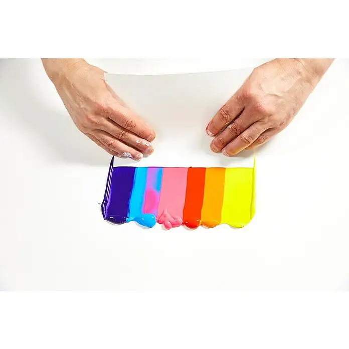 Liquitex Basics Acrylfarbe - Ungebleichtes Titan, 400 ml - Ein weißes Blatt Papier wird auf verschiedene Farbtöne gelegt. Die Farben reichen von Lila bis Gelb und werden von Händen gehalten.