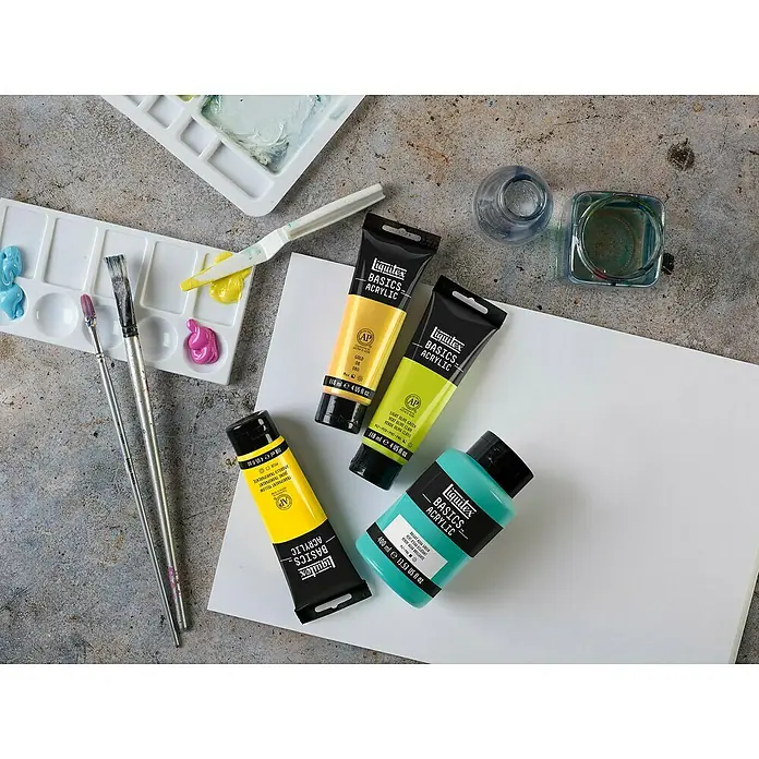 Liquitex Basics Acrylfarbe - Ungebleichtes Titan, 400 ml - Nahaufnahme von Liquitex Basics Acrylfarben in Gelb-, Grün- und Türkistönen, ergänzt durch Malutensilien wie Pinsel und Paletten.