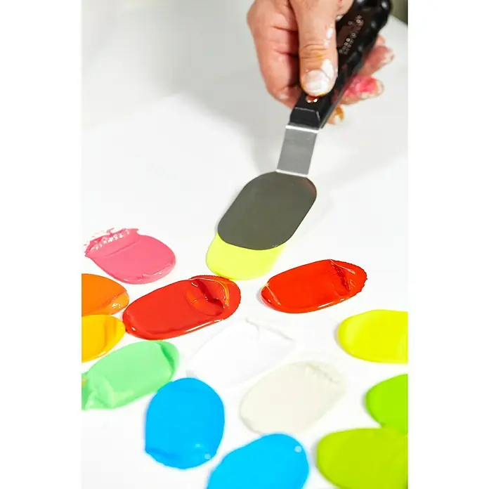 Liquitex Basics Acrylfarbe - Ungebleichtes Titan, 400 ml - Farbige Farbtupfer auf einer Oberfläche, mit einem Spachtel in der Hand, der Farben mischt und verteilt für ein lebendiges, kreatives Kunstwerk.