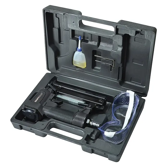 Craftomat Kit Line Druckluft-Klammergerät - Betriebsdruck: 6 bar - 7 bar, Geeignet für: Klammern von 10 - 25 mm - Ein schwarzer Werkzeugkoffer ist geöffnet und beinhaltet eine Nagelpistole, Sicherheitsbrille und eine Flasche Öl.