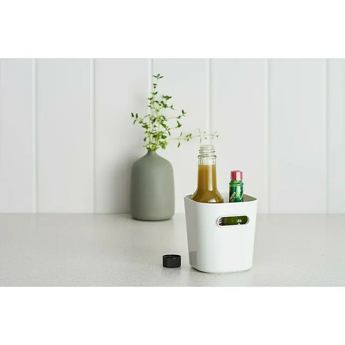 SmartStore Aufbewahrungsbox Compact - L x B x H: 9,8 x 9,4 x 10,2 cm, Kunststoff, Weiß - Nahaufnahme eines weißen Aufbewahrungsbehälters mit zwei Saucenflaschen, der auf einer Küchentheke neben einer Vase mit Grünpflanzen steht.