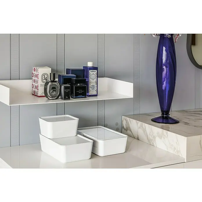 Regalux Aufbewahrungsbox R-BoxL x B x H: 24 x 8 x 17 cm, Kunststoff, Weiß - Elegantes Stillleben mit luxuriösen Parfums auf einem weißen Regal, ergänzt durch stilvolle Aufbewahrungsboxen und eine dekorative blaue Vase.