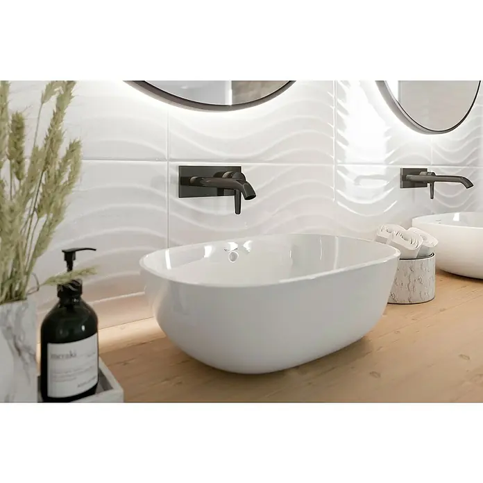 Ambiente by Palazzo Wandfliese Snowwhite Wave - 30 x 60 cm, Stärke: 9 mm, Weiß, Glänzend - Stilvolles Badezimmer-Design mit einem eleganten, weißen Aufsatzwaschbecken und einer modernen, dunklen Armatur.