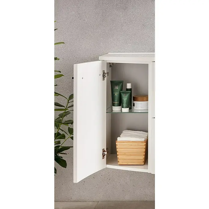 Camargue Swing K Badmöbel-Set AF1 - Gesamtbreite Badmöbel: 120 cm, Dark Oak, Matt, 3 -tlg. - Ein geöffneter weißer Badezimmerschrank mit verschiedenen Hautpflegeprodukten von Rituals und einem Behälter mit weißen Handtüchern.