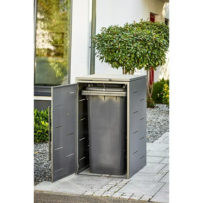 Sunfun Mülltonnenbox - B x T: 67 x 81,5 cm, Anthrazit, Stahl, Geeignet für Anzahl Mülltonnen: 1 Stk. - Ein Mülltonnenbox aus Metall mit einer geöffneten Tür, die eine graue Mülltonne zeigt. Sie steht auf einem gepflasterten Weg vor einem Haus.