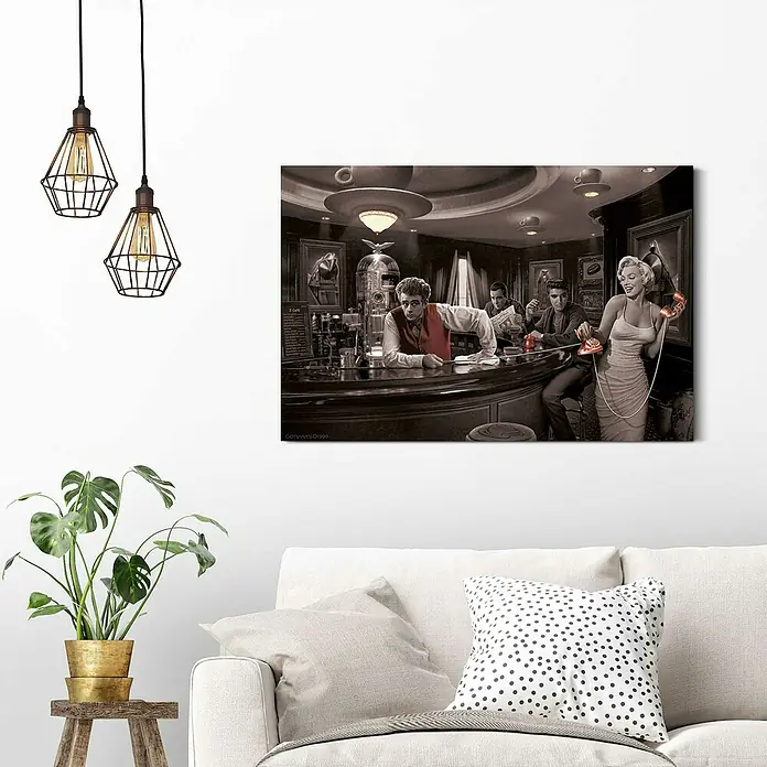 Reinders Decopanel - Chris Consani - Java Dreams, B x H: 90 x 60 cm - Schwarz-Weiß-Leinwandbild, das eine Bar-Szene mit Prominenten wie Marilyn Monroe und James Dean zeigt, aufgehängt über einem Sofa.