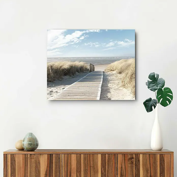 Reinders Decopanel - Dunes, B x H: 50 x 40 cm - Ein Leinwanddruck mit einem Holzsteg, der zu einem Strand führt, hängt über einem Holzschrank. Das Bild strahlt Ruhe und Naturschönheit aus.