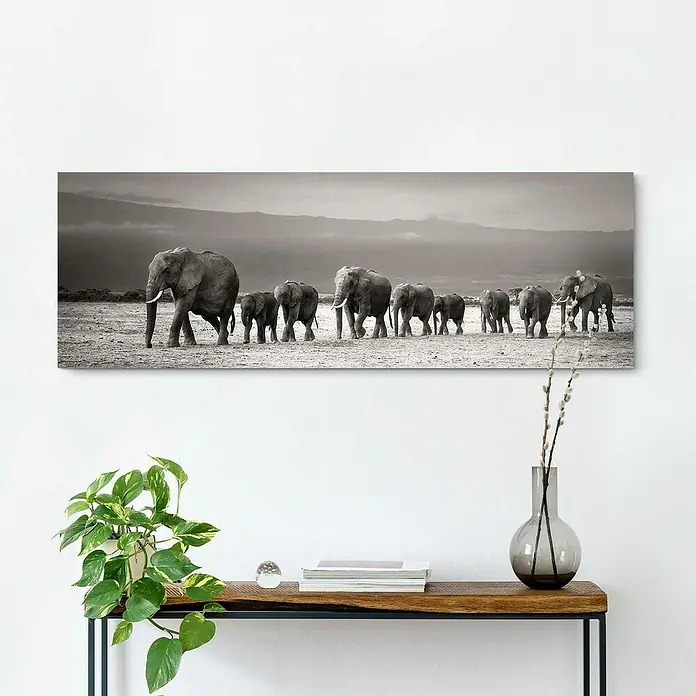 Reinders Holzbild Deco Block - Line of Elephants, B x H: 118 x 40 cm - Eine Schwarzweiß-Leinwand zeigt eine Elefantenfamilie, die durch eine weite Ebene vor einem Bergpanorama zieht.