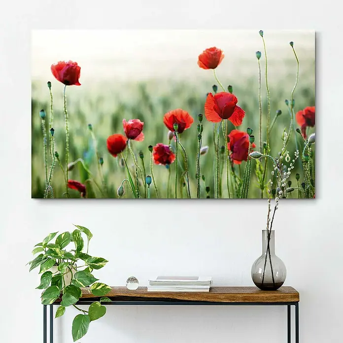 Reinders Holzbild Deco Block - Wild Poppies, B x H: 118 x 70 cm - Ein Gemälde mit roten Mohnblumen in einem grünen Feld hängt über einem Tisch mit einer Pflanze und einer Vase.