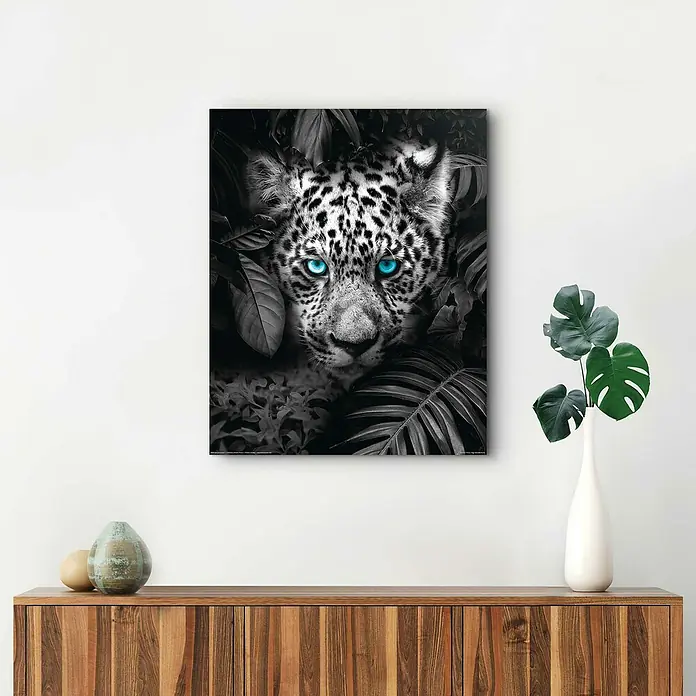 Reinders Decopanel - Blue Eyed Leopard, B x H: 40 x 50 cm - Wandbild mit einem Leopardenkopf in Schwarzweiß und leuchtend blauen Augen, umgeben von tropischen Blättern. Perfekt für moderne Wohnräume.