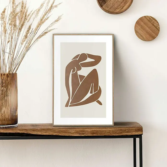 Reinders Bild Slim Frame Wood - Body Lines, B x H: 20 x 30 cm - Ein stilvolles Kunstwerk mit einer braunen Figur, gerahmt und auf einem Holztisch präsentiert, neben einer Vase mit Trockenblumen.