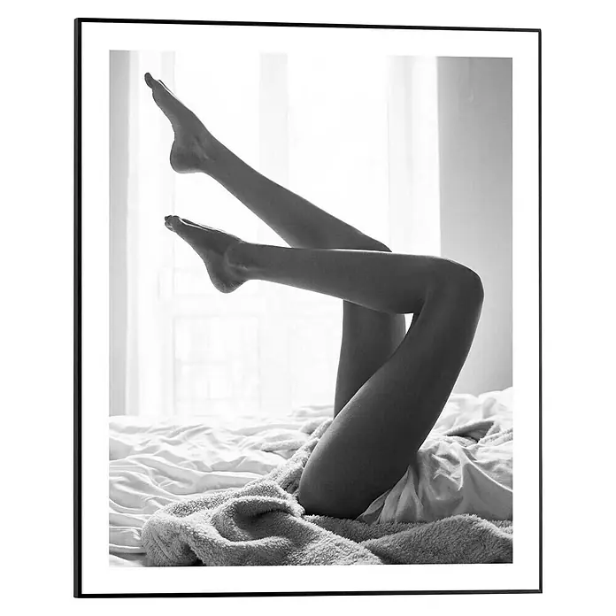 Reinders Bild Slim Frame Black - Legs Up, B x H: 40 x 50 cm - Schwarz-Weiß-Foto zeigt Beine, die in der Luft liegen, während der Körper unter einer Decke im Bett liegt. Minimalistisch und künstlerisch.