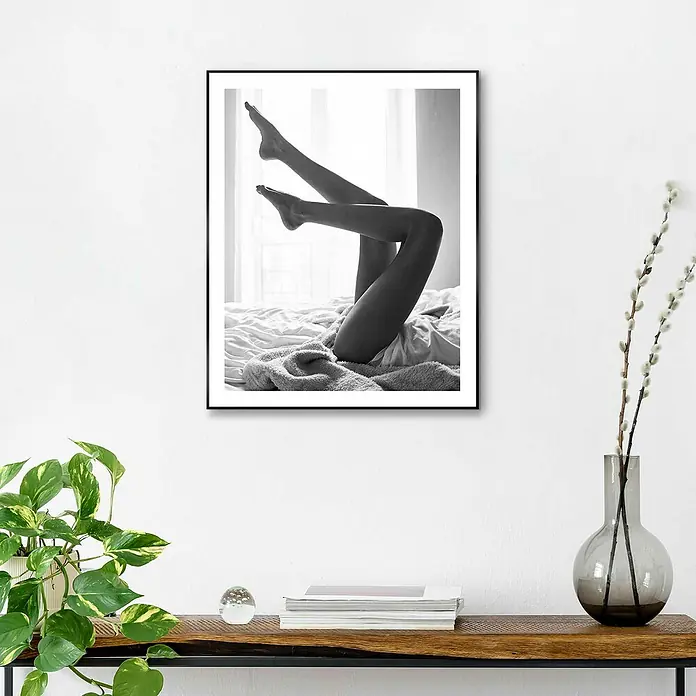 Reinders Bild Slim Frame Black - Legs Up, B x H: 40 x 50 cm - Schwarz-Weiß-Druck eines Fotos von hochgestreckten Beinen auf einem Bett, gerahmt und an einer weißen Wand aufgehängt.