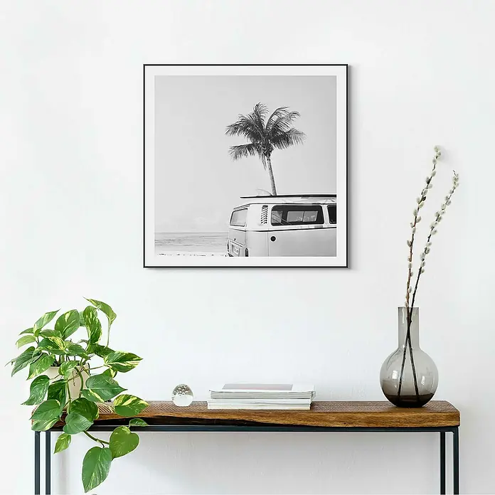 Reinders Bild Slim Frame BlackSummer Vibe, B x H: 50 x 50 cm - Schwarz-Weiß-Fotodruck eines VW-Busses mit Palme auf einem Tisch mit Pflanze, Glaskugel, Büchern und einer Vase mit Zweigen.