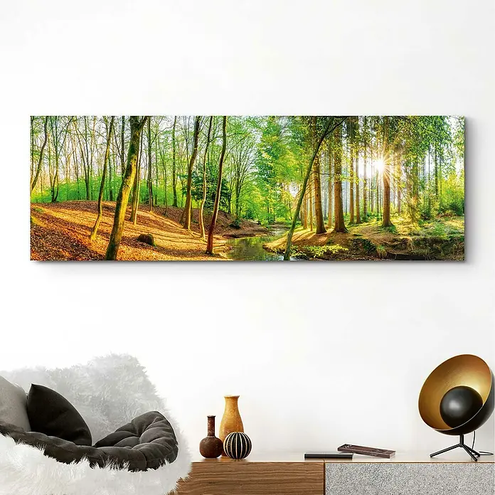 Reinders Decopanel - Spring Woods, B x H: 156 x 52 cm - Wandbild eines malerischen Waldwegs mit Sonnenstrahlen, die durch die Bäume scheinen, über einem eleganten Sideboard platziert.
