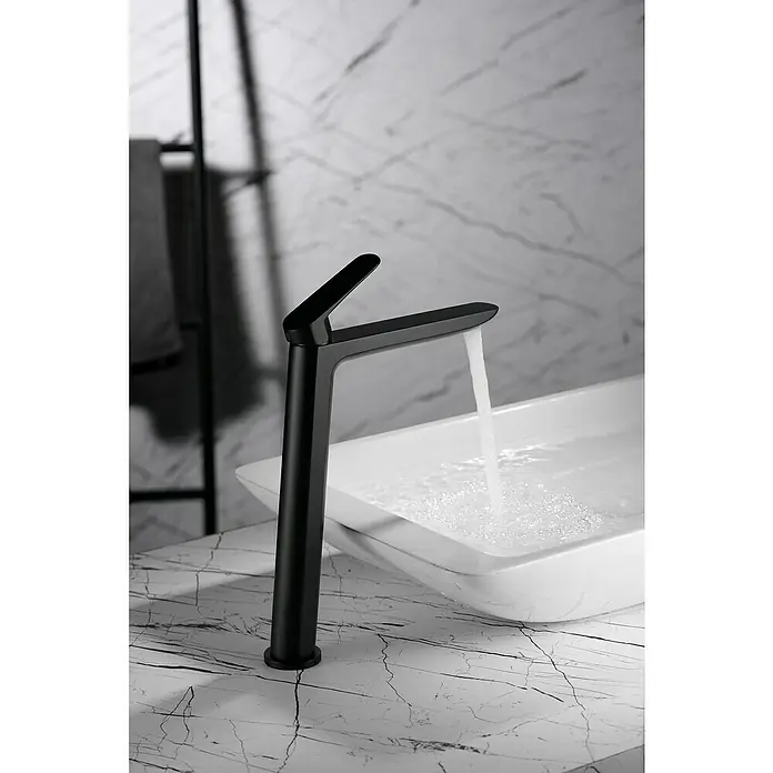 Imex Bélgica Grifo de lavabo alto - Negro - Elegante grifo de baño negro mate moderno con líneas limpias y agua que fluye en un elegante lavabo sobre una encimera de mármol.