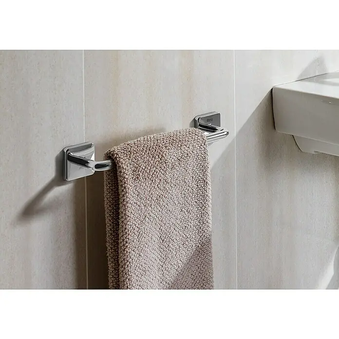 Roca Victoria Toallero - Ancho: 30 cm, Pegado, Resplandeciente - Primer plano de un toallero con una toalla beige en un baño, al lado de un lavabo.