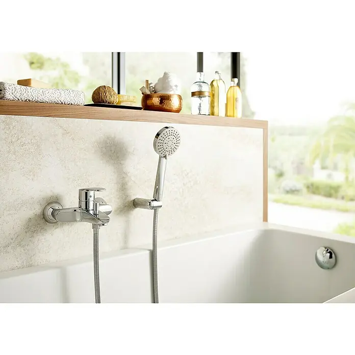 Roca Eos-N Grifo monomando de bañera - Cromo, Brillante - Primer plano de un moderno grifo de bañera con ducha de mano. El acabado cromado y el diseño minimalista añaden un toque de elegancia al baño.