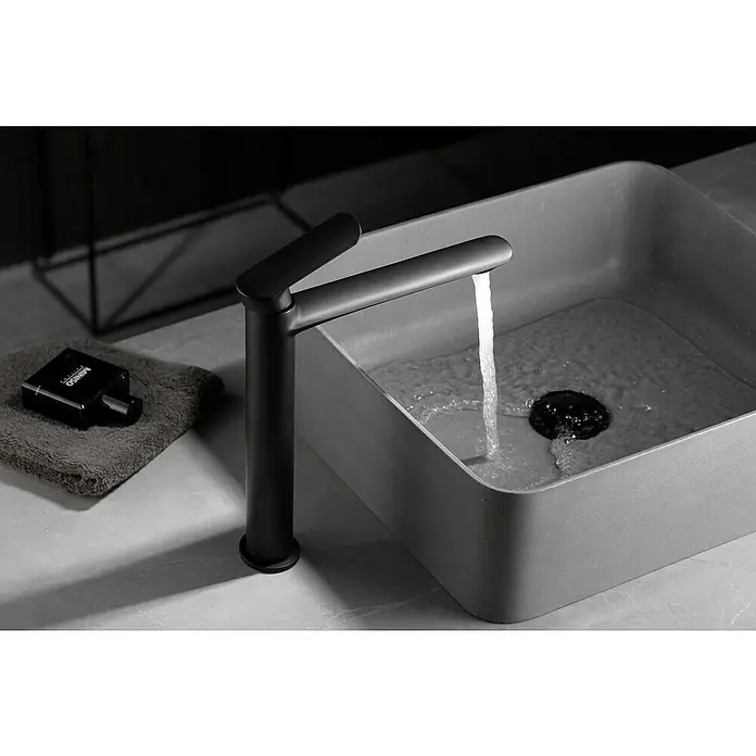 Imex Ural Grifo de lavabo alto - Negro - Elegante grifo de lavabo negro mate con líneas limpias vertiendo agua en un lavabo moderno. Diseño de baño en foco.