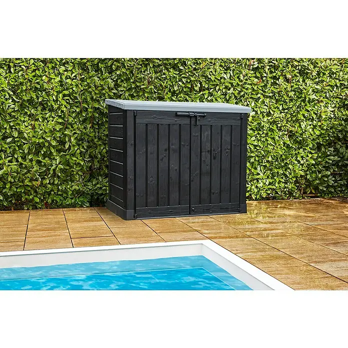 Keter Truhe Store it out Max - L x B x H: 145,5 x 82 x 125 cm, Anthrazit/Grau - Diese Aufnahme zeigt eine schwarze Gartenbox mit grauem Deckel, ideal zur Aufbewahrung im Freien, neben einem Pool auf Steinfliesen.