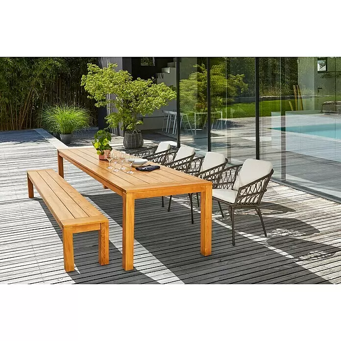 Sunfun Laura Gartentisch - L x B x H: 300 x 100 x 76 cm, Akazie, Rechteckig, Braun - Essgruppe für draußen: Holztisch, Bank und geflochtene Stühle mit hellen Kissen auf einer Terrasse.