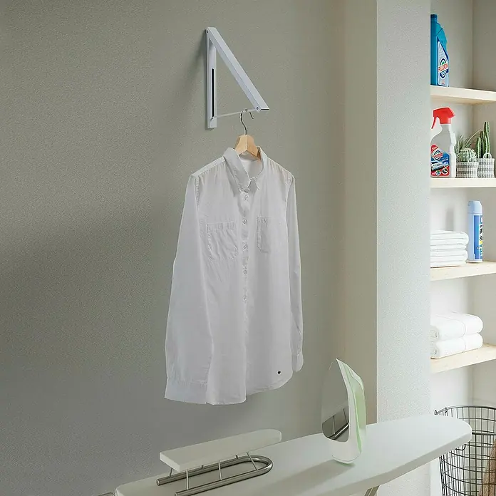 Perchero plegable - L x An x Al: 30 x 28 x 4 cm, Metal, Blanco - Tendedero de pared con una camisa blanca. Solución práctica y ahorra espacio para secar la ropa.