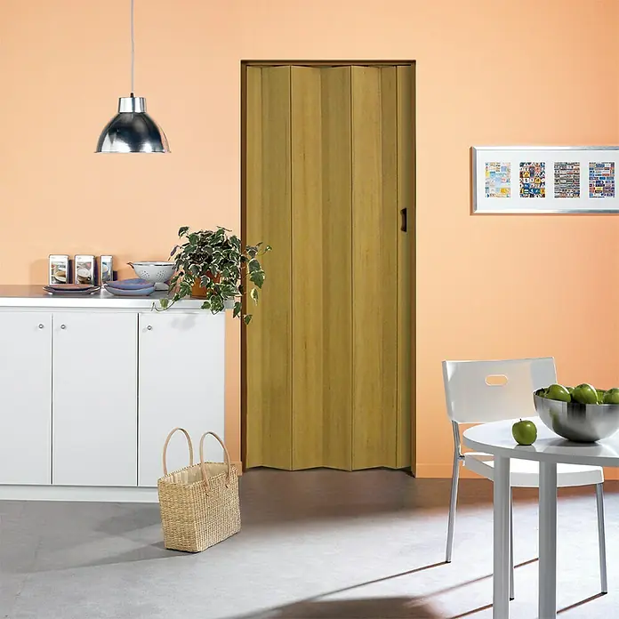 Grosfillex Falttür Una - 84 x 205 cm, Altholzeffekt - Ein Bild von einer harmonischen Küchenszene mit einer gelben Falttür als zentralem Element, umgeben von weißen Möbeln und Dekorationen.