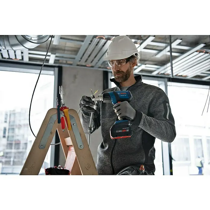 Bosch Professional AMPShare 18V Akku-Heißluftgebläse GHG18V-50 - 18 V, Ohne Akku, Temperaturbereich: 300 °C - 500 °C, Kunststoffkoffer - Ein Bauarbeiter mit einem Bosch Akku-Heißluftgebläse GHE 18V-50, ideal für schnelles Erhitzen und Formen.