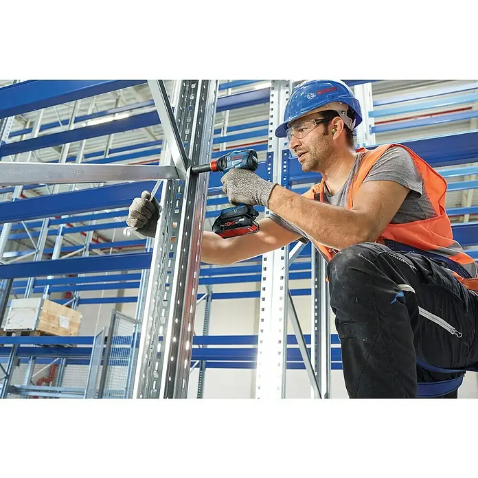 Bosch Professional AMPShare 18V Akku-Drehschlagschrauber GDX 18V-210 C - 18 V, Ohne Akku, 210 Nm, Mit Bluetooth-Modul - Ein Handwerker mit Bosch Akku-Schlagschrauber beim Aufbau eines Metallregals in einer Lagerhalle.