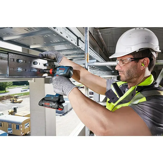 Bosch Professional AMPShare 18V Akku-Drehschlagschrauber GDX 18V-210 C - 18 V, Ohne Akku, 210 Nm, Mit Bluetooth-Modul - Ein Bauarbeiter befestigt mit einem Bosch Akku-Schlagschrauber eine Metallschiene. Der Bosch Schlagschrauber ist ein zuverlässiges Werkzeug.