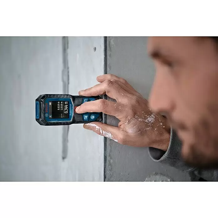 Bosch Professional Laserentfernungsmesser GLM 50-22 - Messbereich: 0,05 - 50 m - Eine Person nutzt ein schwarz-blaues Bosch Professional Laser-Distanzmessgerät und zeigt 6,344 m an einer Wand.