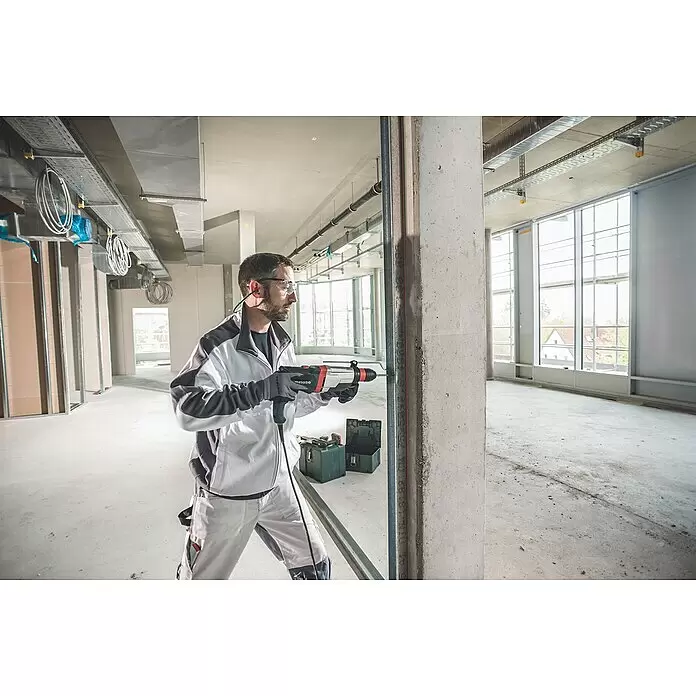 Metabo Martillo combinado UHE 2860-2 Quick - 1.100 W, 3,4 J, Alojamiento SDS-Plus - Hombre perfora un pilar de hormigón con un taladro percutor Metabo en una obra.