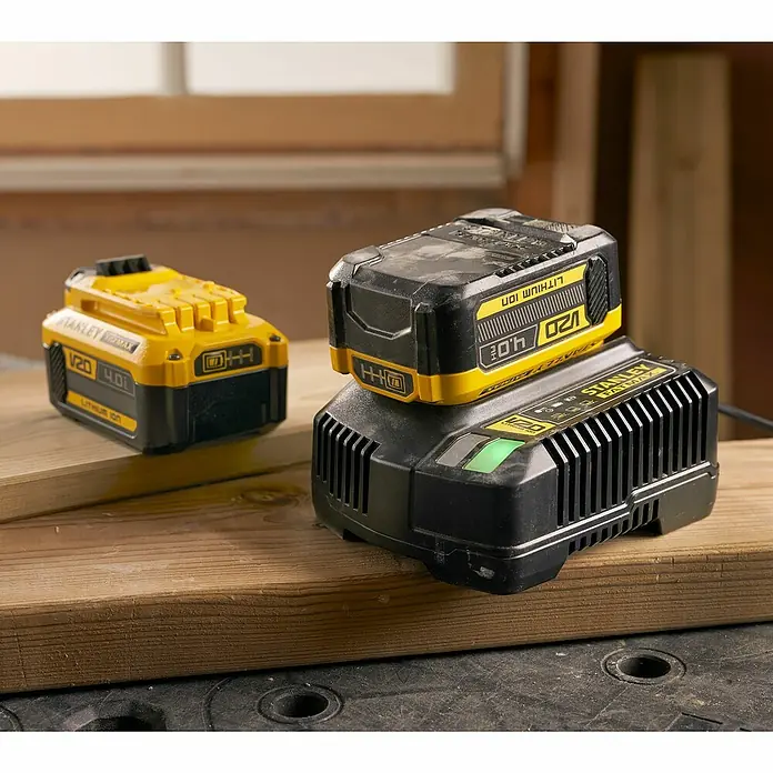 Stanley FatMax Akku SFMCB204-XJ - 18 V, 4 Ah - Stanley V20 Akku und Ladegerät auf einer Holzoberfläche.