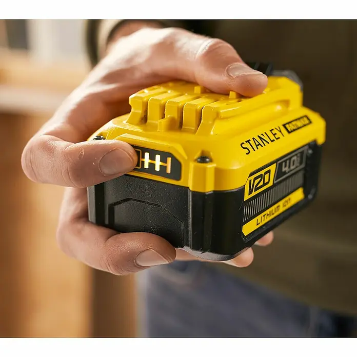 Stanley FatMax Akku SFMCB204-XJ - 18 V, 4 Ah - Nahaufnahme einer STANLEY FATMAX 20V 4.0Ah Lithium-Ionen-Batterie, die von einer Hand gehalten wird. Gelb und schwarz mit Batterieanzeige.