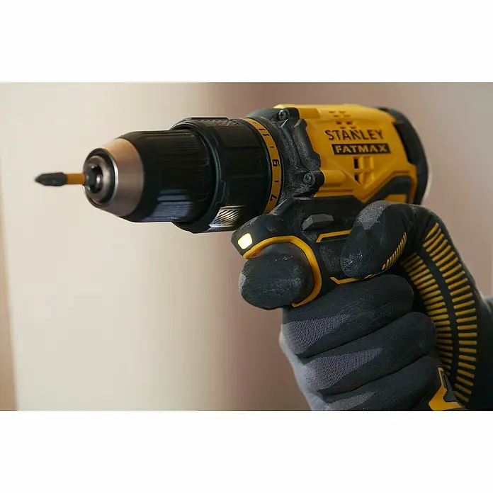 Stanley FatMax Akku-Bohrschrauber SFMCD710D2K-QW - 18 V, 2 Akkus, 2 Ah, 60 Nm - Nahaufnahme eines Stanley Fatmax Akku-Bohrers in der Hand eines Bauarbeiters mit Handschuhen.