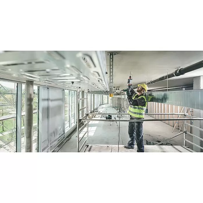 Metabo Martillo combinado 2860 Quick Set - 880 W, 3,2 J, Alojamiento SDS-Plus - Obrero perfora para instalar sistema de bandejas de cables en el techo de una obra.