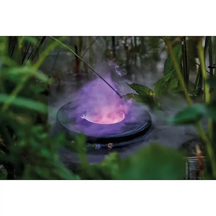 Pontec Vernebler PONDOFOG RGB - Geeignet für: Gartenteiche - Dunkler, runder Vernebler erzeugt lila-rosa Dampf im Wasser zwischen grünen Pflanzen.