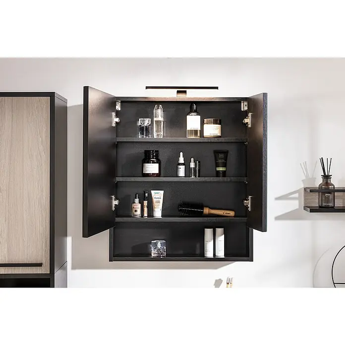 BAUHAUS Jannik LED-SpiegelschrankB x H: 60 x 70 cm, Mit Beleuchtung, Holz, Anthrazit - Ein offener Badezimmerschrank mit verschiedenen Pflegeprodukten, darunter Cremes, Lotionen und Parfums, die auf den Regalen angeordnet sind.