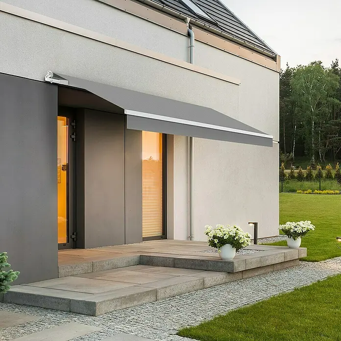 SmartSun Toldo de brazos extensibles Original Kit Polie - Gris claro, Ancho: 4 m, Caída: 2,5 m - Toldo gris sobre una entrada moderna de una casa, que proporciona sombra y complementa el diseño arquitectónico.