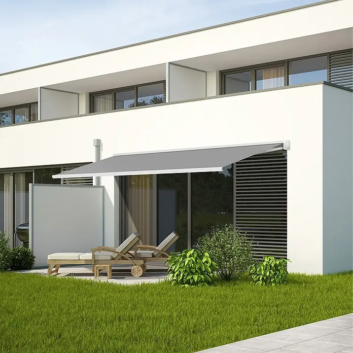 SmartSun Toldo de brazos extensibles Fiji - Gris piedra, Ancho: 4 m, Caída: 3 m - Toldo gris fijado a un edificio blanco moderno, que ofrece sombra y mejora la zona exterior. Relajantes tumbonas en el jardín.