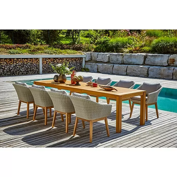 Sunfun Laura Gartentisch - L x B x H: 300 x 100 x 76 cm, Akazie, Rechteckig, Braun - Eine Outdoor-Essgruppe mit Holztisch und hellen Korbstühlen mit grauen Kissen, auf einer Terrasse am Pool.