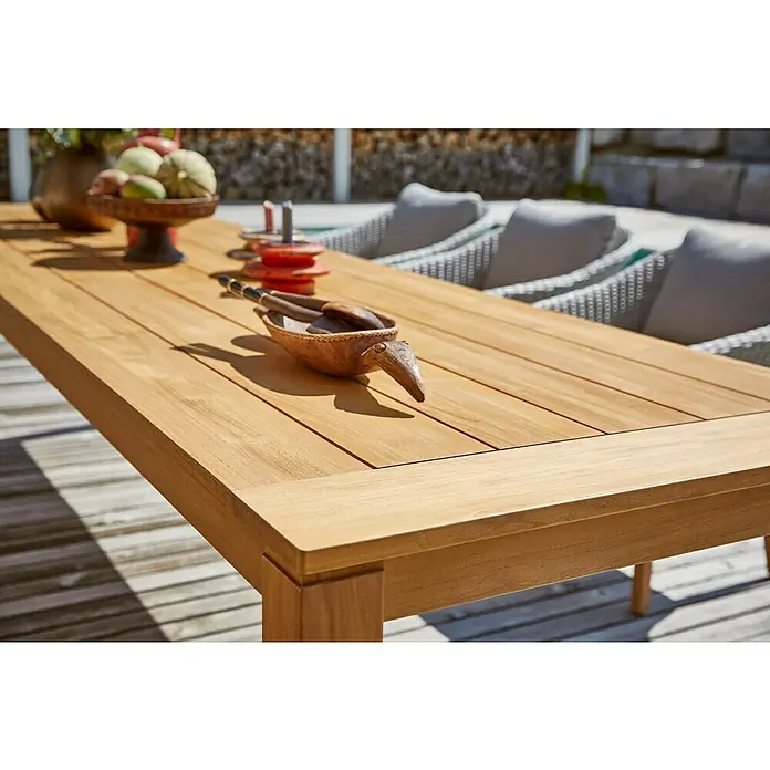 Sunfun Gartenmöbel-Set Laura/Kathrin - 6 -tlg., Akazie/Polyesterfaser/Aluminium, Naturbraun/Hellgrau, Gartenstuhl klappbar - Nahaufnahme eines Tisches aus Teakholz mit Dekorationsgegenständen, der im Freien steht und eine warme Atmosphäre schafft.
