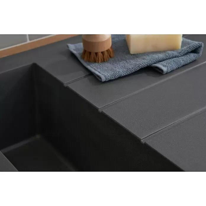 Respekta Einbauspüle Alineo - 50 x 100 cm, Titangrau - Dunkelgraues Küchenspülbecken mit integriertem Abtropfbrett, darauf Bürste, Seife und Tuch.