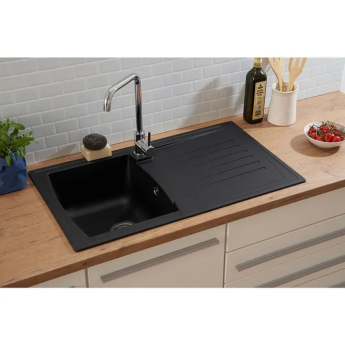 Respekta Einbauspüle Boston - 86 x 50 cm, Schwarz - Eine moderne, schwarze Spüle mit Abtropffläche und einem glänzenden Wasserhahn, eingebettet in eine helle Holzarbeitsplatte.