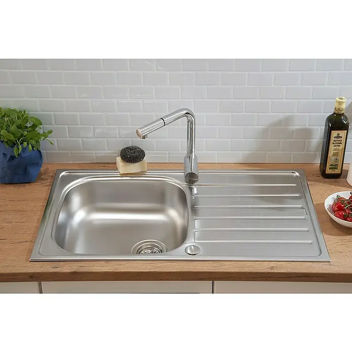 Respekta Fregadero encastrable Dallas - 86 x 50 cm, Acero inoxidable - Fregadero de acero inoxidable con escurridor, grifo, esponja, jabón y utensilios de cocina sobre una encimera de madera con azulejos blancos.