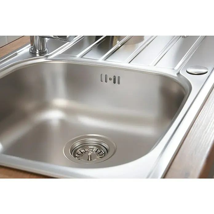Respekta Fregadero encastrable Dallas - 86 x 50 cm, Acero inoxidable - Una vista cercana de un fregadero brillante de acero inoxidable con desagüe y escurridor integrado, destacando la estética moderna de la cocina.
