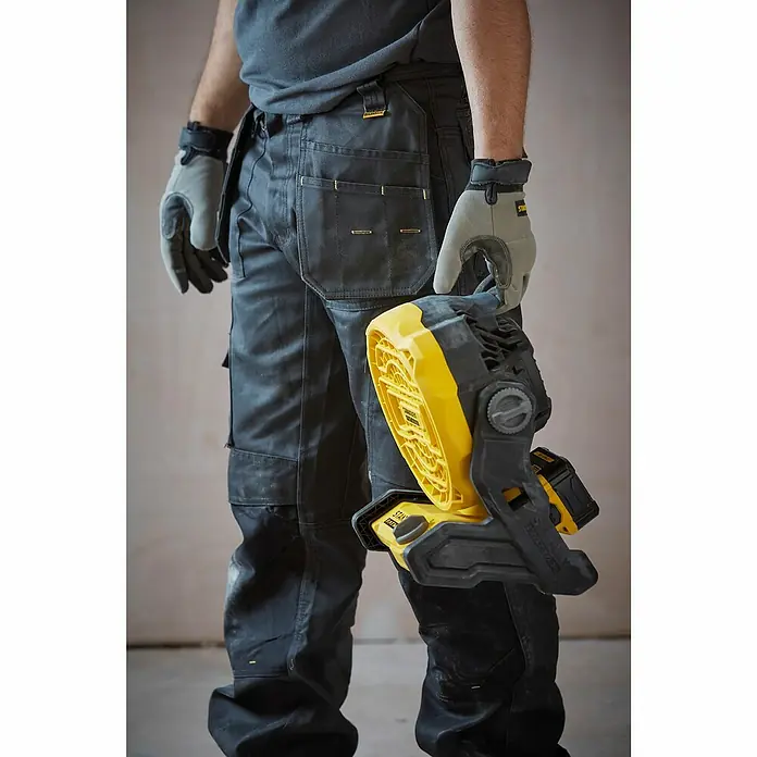 Stanley FatMax Akku-Ventilator SFMCE001B-XJ - 18 V, Ohne Akku, Luftmenge: 1.100 m³/h - Der Arbeiter hält eine gelbe Stanley-Arbeitsleuchte. Das Produkt ist robust und leistungsstark, perfekt für den Einsatz auf Baustellen.
