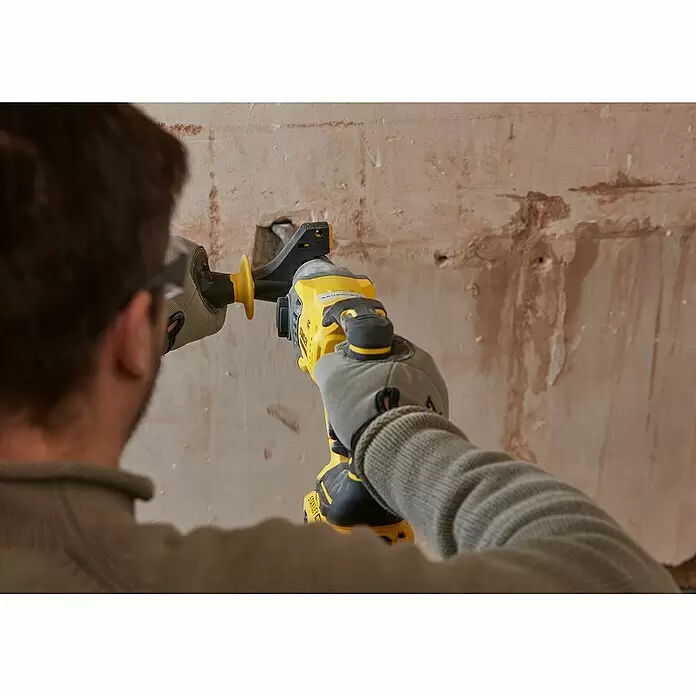 Stanley FatMax Akku-Kombihammer SFMCH900B-XJ - 18 V, Ohne Akku, 2 J - Eine Person nutzt einen gelb-schwarzen Stanley Akku-Bohrhammer zum Meißeln in eine strukturierte Wand.
