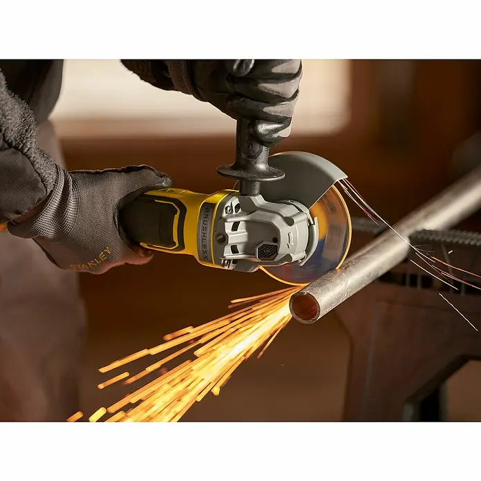 Stanley FatMax Akku-Winkelschleifer SFMCG700M2K-QW - 2 Akkus, 4 Ah, Durchmesser Scheibe: 125 mm - Eine Akku-Winkelschleifmaschine von Stanley wird zum Schneiden eines Metallrohrs mit vielen Funken verwendet.